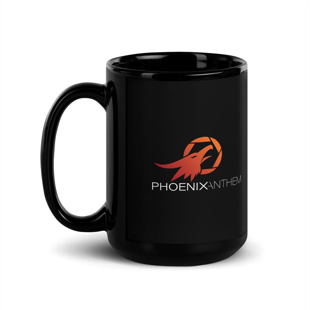 Left-handle view of the Phoenix Anthem glossy black mug. A striking ceramic design with red-orange logo and a smooth finish that reflects bold faith and craftsmanship.