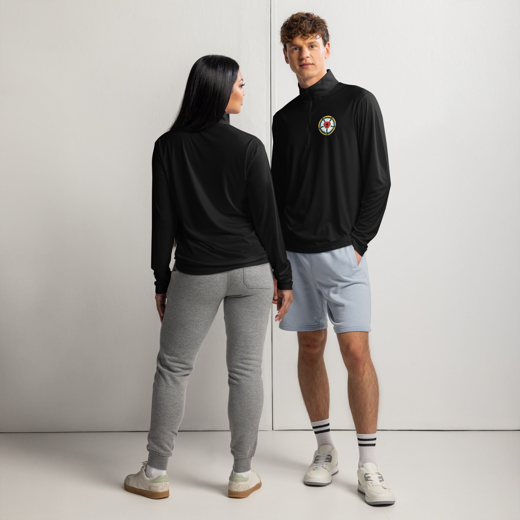 Full body mock-up showcasing the front and back view of the unisex black quarter-zip lightweight pullover jacket with the Luther Rose emblem, styled as confessional Christian lifestyle apparel.