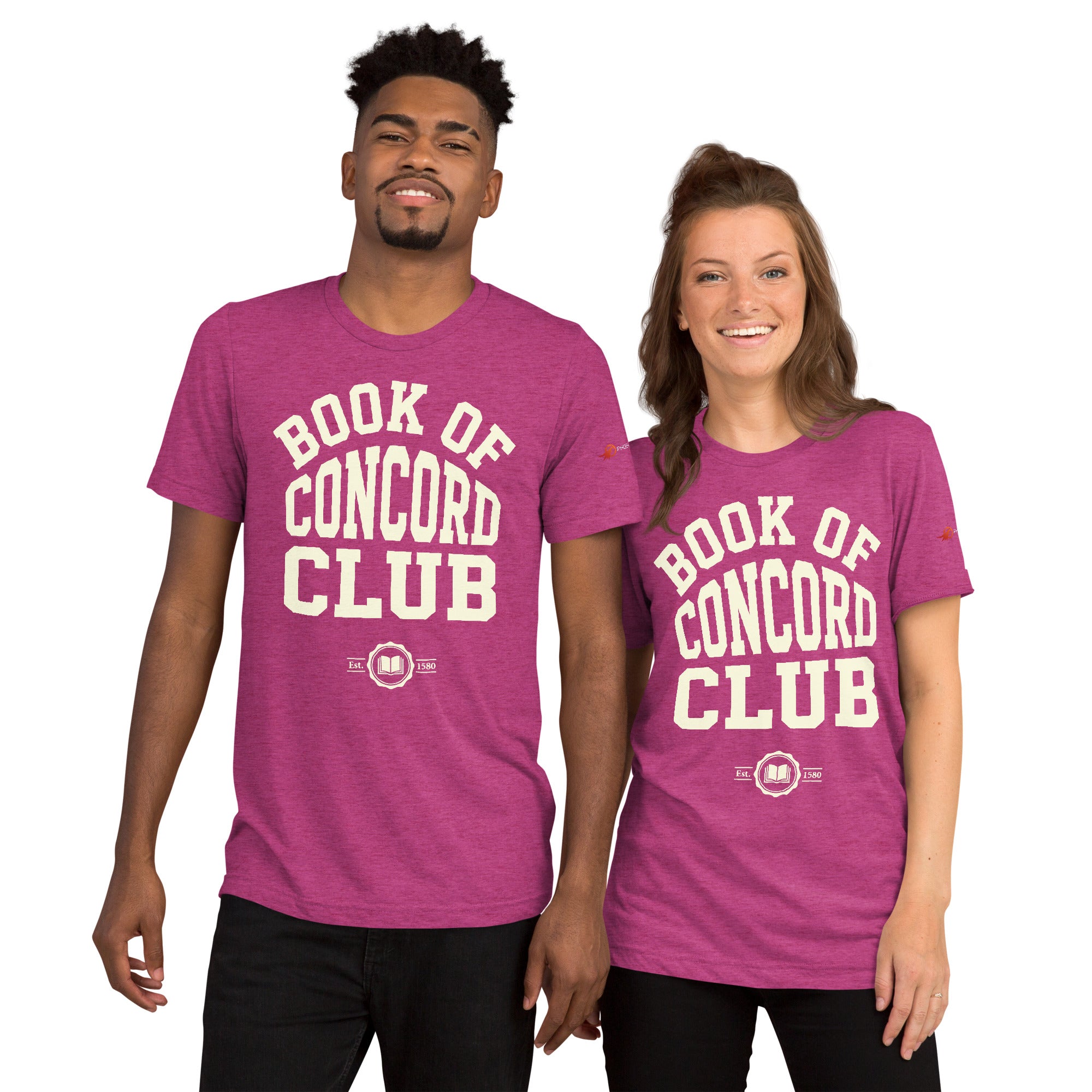 A man and woman modeling matching berry tri-blend t-shirts featuring a collegiate "Book of Concord Club Est. 1580" graphic design. Premium Lutheran apparel and Christian theology clothing for men and women.