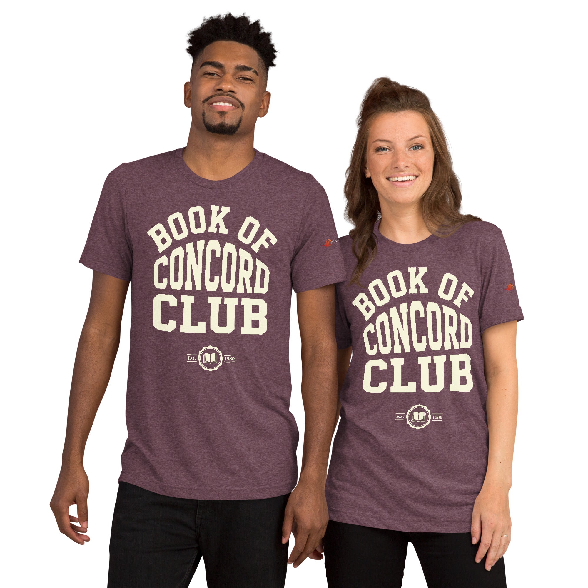 A man and woman modeling matching maroon tri-blend t-shirts featuring a collegiate "Book of Concord Club Est. 1580" graphic design. Premium Lutheran apparel and Christian theology clothing for men and women.