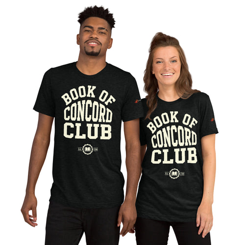 A man and woman modeling matching black tri-blend t-shirts featuring a collegiate "Book of Concord Club Est. 1580" graphic design. Premium Lutheran apparel and Christian theology clothing for men and women.