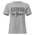 Front view of an athletic heather grey women's relaxed-fit Christian t-shirt with black text reading 'JUSTIFIED by Grace' in a clean serif and script font combination. Premium Lutheran faith-based apparel from Phoenix Anthem.