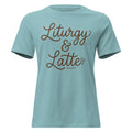 Front view of a heather blue lagoon women's relaxed-fit Christian t-shirt featuring the phrase 'Liturgy & Latte' in a brown cursive script with a small book and coffee bean icon. Liturgical faith-based apparel from Phoenix Anthem.