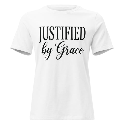 Front view of a white women's relaxed-fit Christian t-shirt with black text reading 'JUSTIFIED by Grace' in a clean serif and script font combination. Premium Lutheran faith-based apparel from Phoenix Anthem.